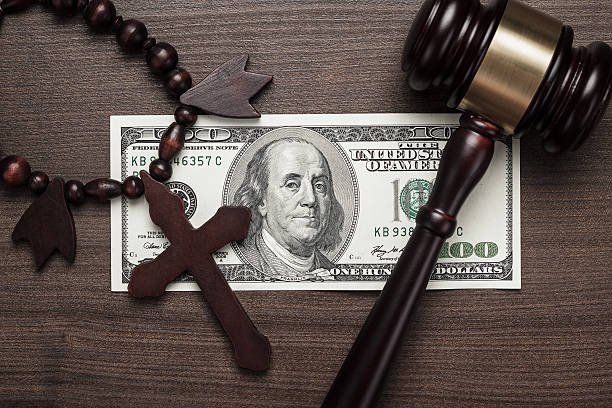 wooden cross gavel and money on brown table background concept